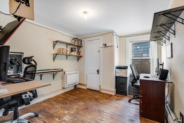 office area featuring baseboards, heating unit, and hardwood / wood-style floors