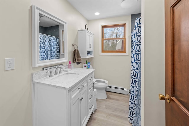 full bath featuring baseboard heating, toilet, vanity, and wood finished floors