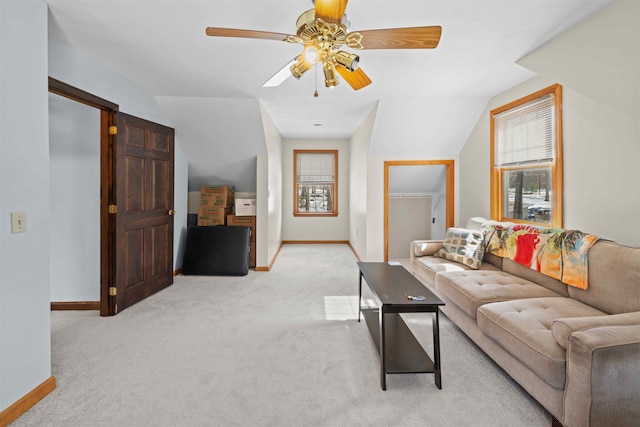 living area featuring lofted ceiling, light colored carpet, baseboards, and ceiling fan