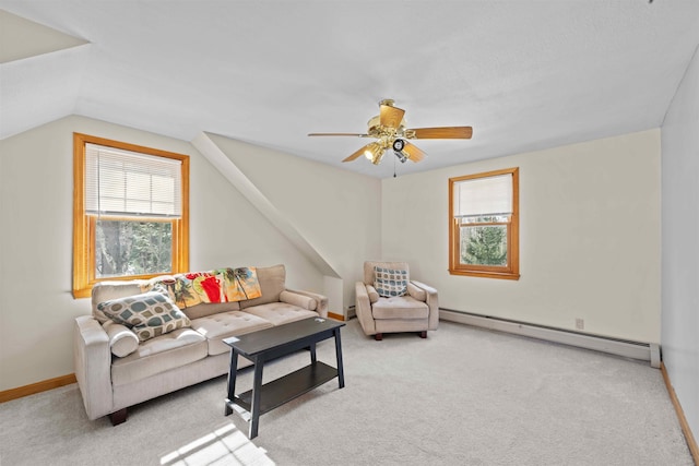 living area with light carpet, baseboard heating, and a healthy amount of sunlight