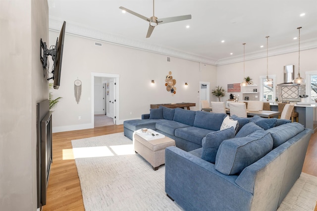 living room with recessed lighting, baseboards, light wood-style floors, and ornamental molding