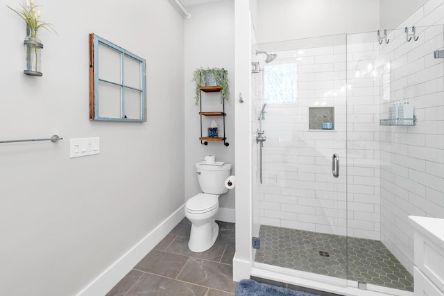 bathroom with a shower stall, toilet, and baseboards