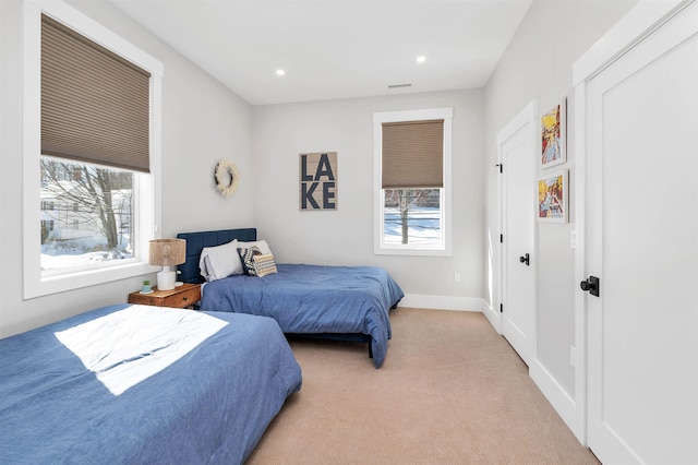 bedroom featuring recessed lighting, baseboards, multiple windows, and light colored carpet