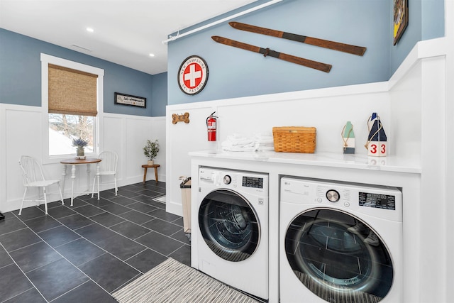 washroom featuring a wainscoted wall, dark tile patterned flooring, recessed lighting, laundry area, and washing machine and clothes dryer