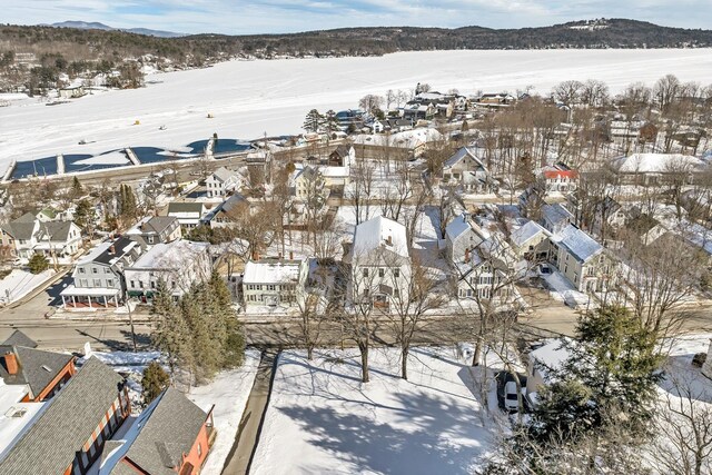 snowy aerial view with a mountain view and a residential view