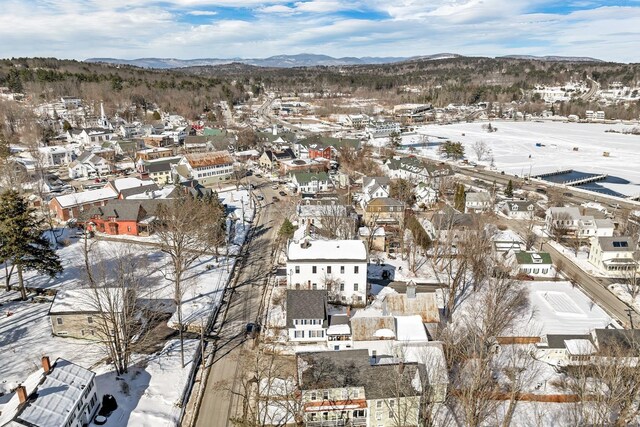 snowy aerial view with a mountain view and a residential view