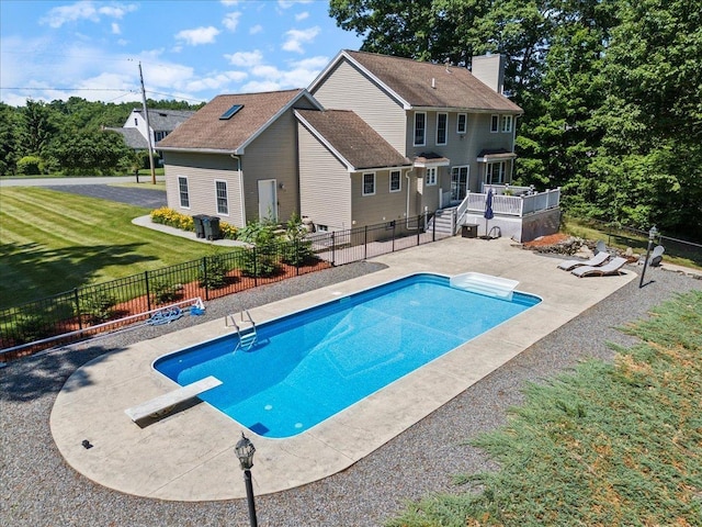 view of pool featuring a fenced in pool, fence, a deck, a patio area, and a lawn