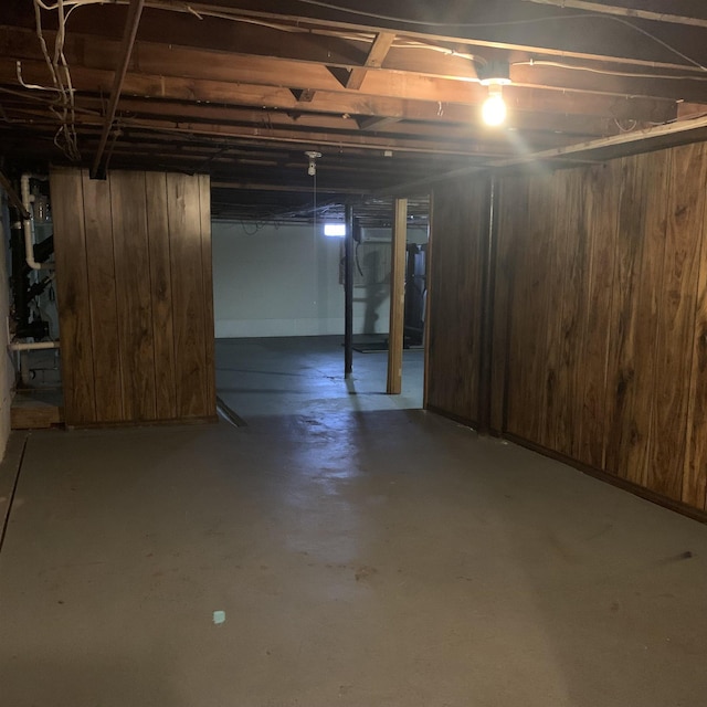 unfinished basement featuring wood walls