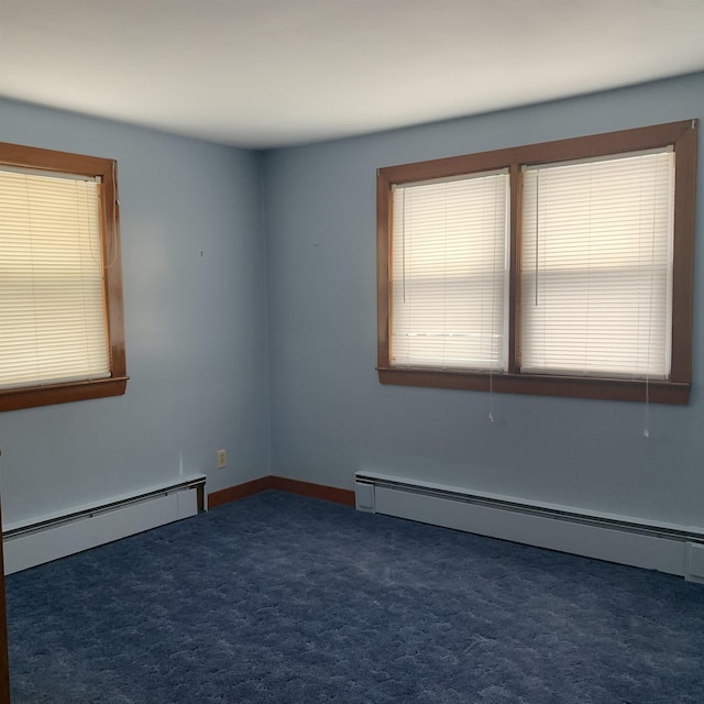 carpeted spare room featuring baseboard heating