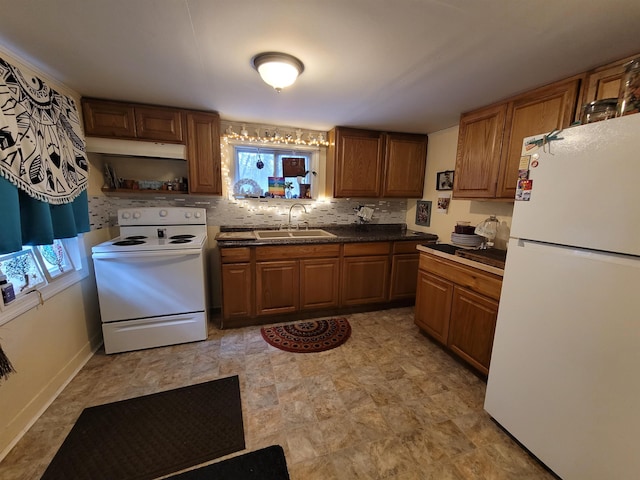 kitchen with brown cabinets, a sink, dark countertops, tasteful backsplash, and white appliances