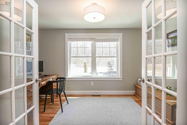 office with french doors, baseboards, and wood finished floors