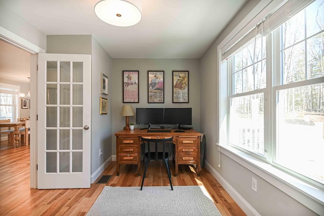 home office featuring visible vents, light wood-type flooring, and baseboards