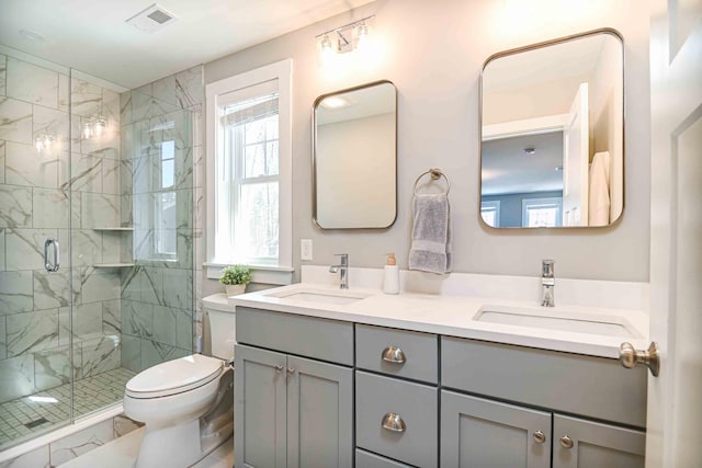 full bath with visible vents, a stall shower, toilet, and a sink