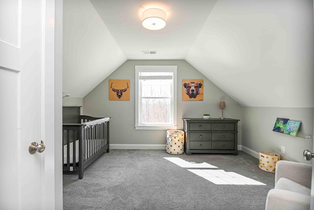 carpeted bedroom with visible vents, a crib, baseboards, and vaulted ceiling