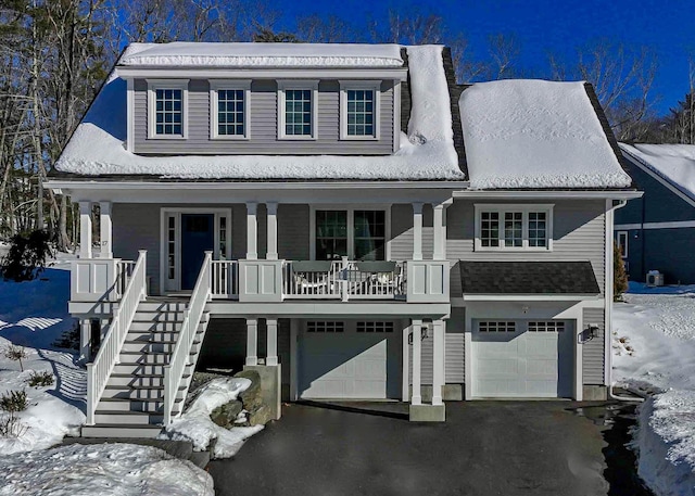 view of front of property with stairway, a garage, covered porch, and driveway