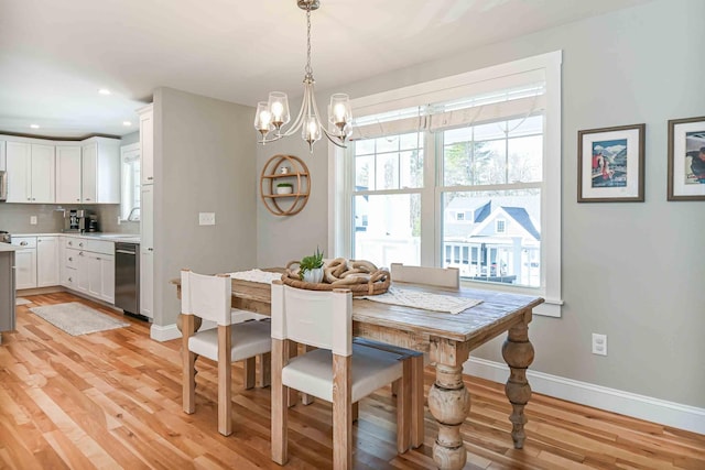 dining space with recessed lighting, baseboards, an inviting chandelier, and light wood-style flooring