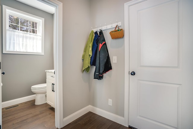 bathroom featuring vanity, wood finished floors, visible vents, baseboards, and toilet