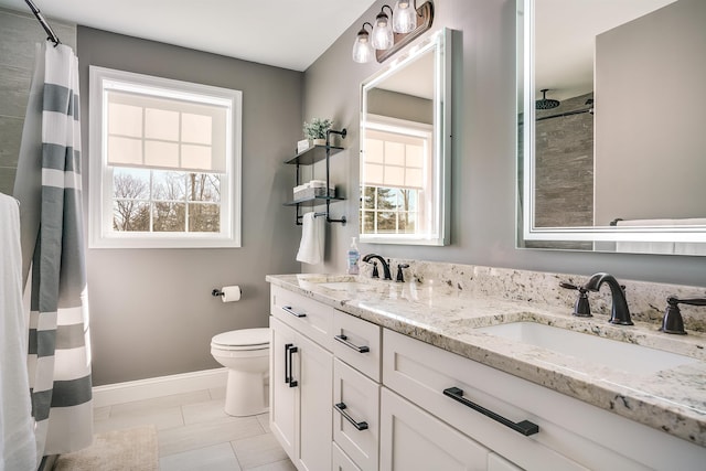 bathroom with a sink, curtained shower, baseboards, and toilet