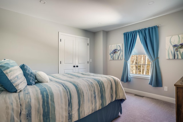 carpeted bedroom featuring a closet, visible vents, and baseboards