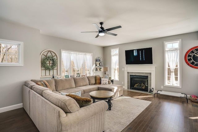 living area with a wealth of natural light, dark wood-style floors, and a fireplace