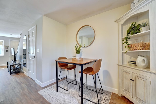 dining space featuring wood finished floors and baseboards