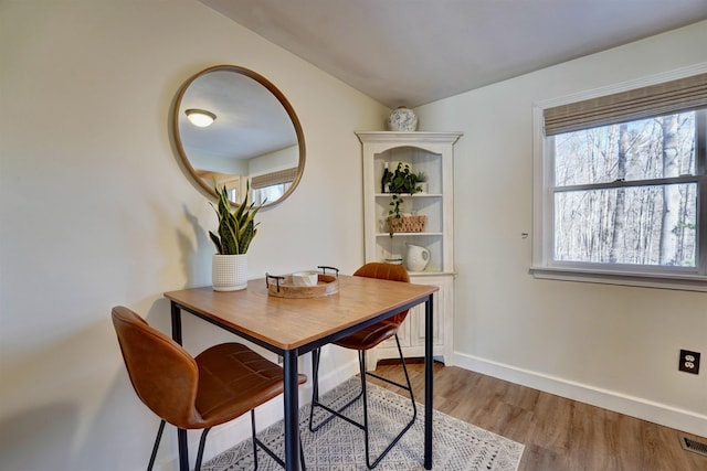 dining space with visible vents, baseboards, and wood finished floors