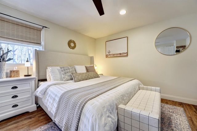 bedroom featuring ceiling fan, baseboards, and wood finished floors