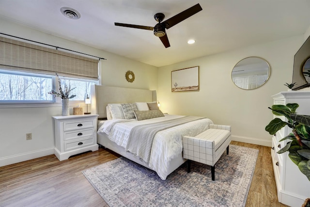 bedroom featuring baseboards, visible vents, and light wood finished floors