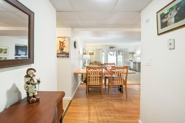 dining space featuring light wood-type flooring and baseboards