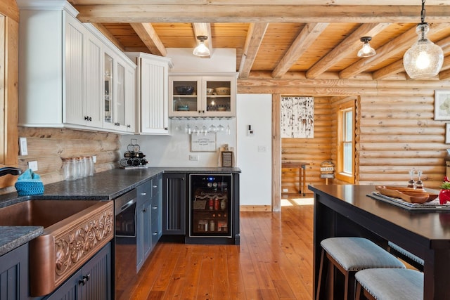 kitchen with wine cooler, light wood-style floors, wood ceiling, and white cabinetry