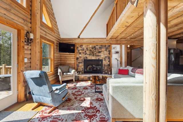 living area with a stone fireplace, wood finished floors, and high vaulted ceiling