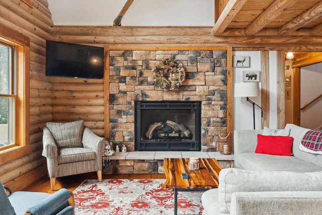 living area featuring a stone fireplace, beamed ceiling, log walls, and wood finished floors