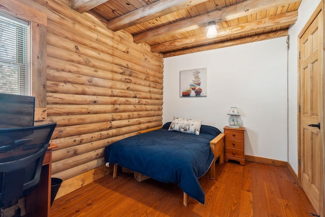 bedroom featuring hardwood / wood-style floors, baseboards, beam ceiling, wooden ceiling, and rustic walls