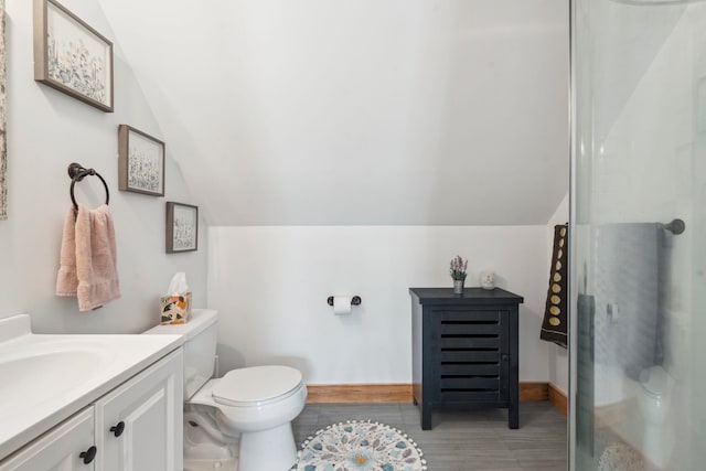 full bathroom featuring vanity, baseboards, vaulted ceiling, an enclosed shower, and toilet