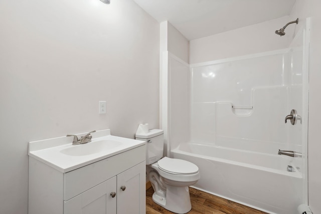 bathroom featuring toilet, wood finished floors,  shower combination, baseboard heating, and vanity