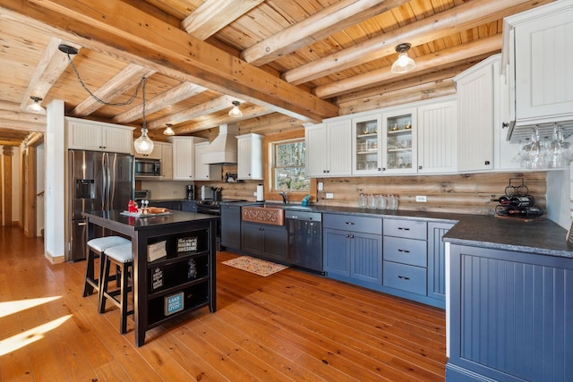 kitchen featuring black appliances, custom range hood, white cabinets, dark countertops, and light wood-type flooring