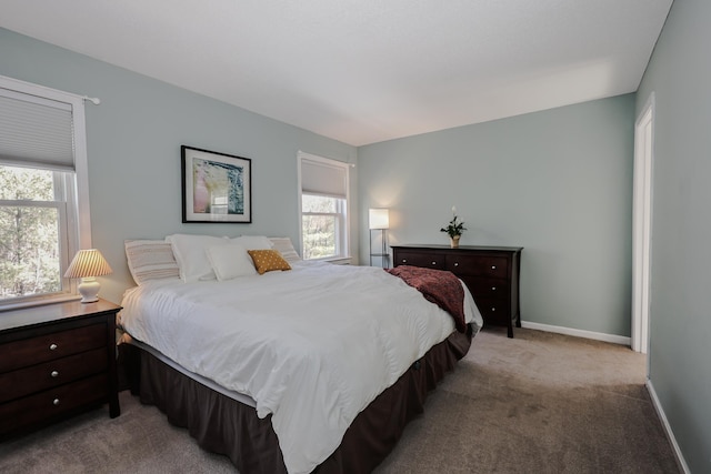 bedroom featuring baseboards and light colored carpet