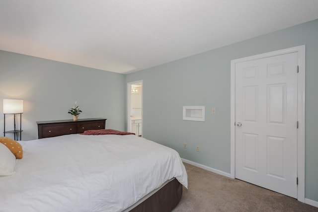 carpeted bedroom featuring baseboards and ensuite bath