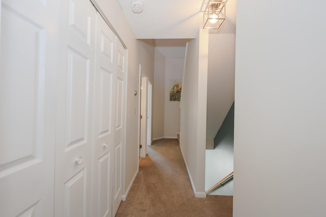 hallway with light colored carpet and baseboards