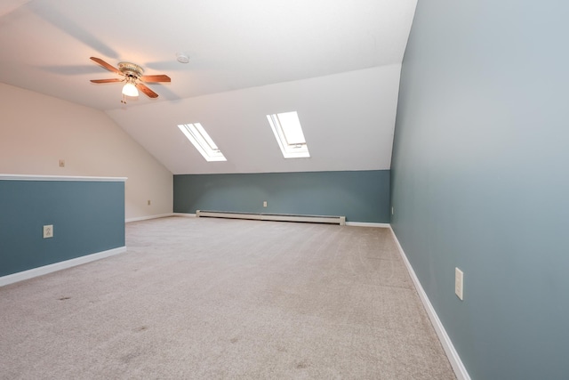 additional living space with a baseboard heating unit, carpet floors, baseboards, and vaulted ceiling