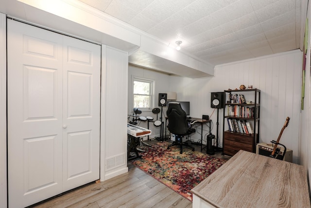 office space with visible vents, ornamental molding, and light wood finished floors