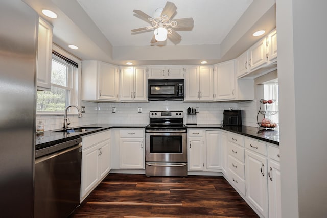 kitchen with dark countertops, dark wood-style floors, stainless steel appliances, and a sink