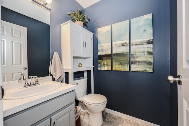 half bath with toilet, vanity, and baseboards