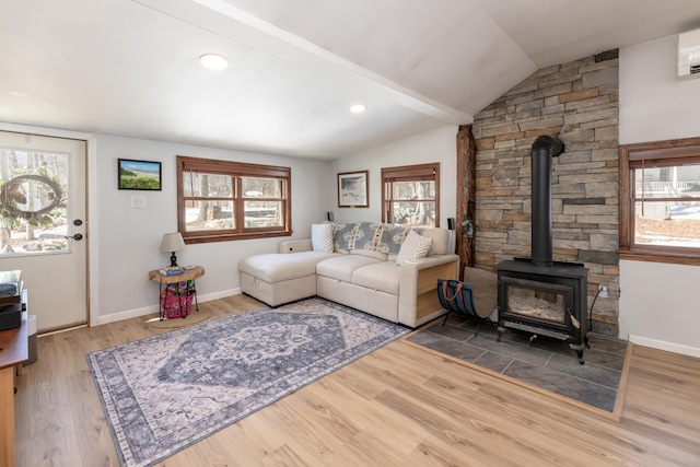 living area featuring lofted ceiling, plenty of natural light, and wood finished floors