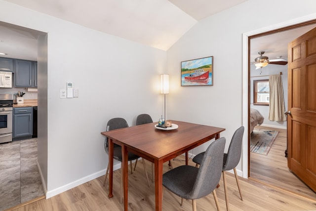 dining area with baseboards, light wood-style floors, lofted ceiling, and a ceiling fan