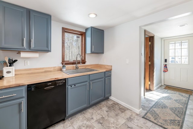 kitchen with a sink, plenty of natural light, butcher block countertops, and dishwasher