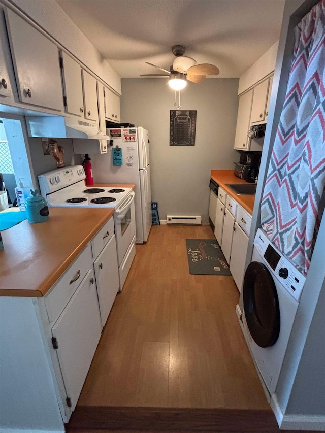 kitchen with white appliances, light wood-style flooring, stacked washer and dryer, white cabinets, and baseboard heating