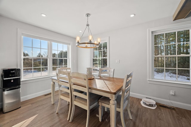 dining space with visible vents, wood finished floors, recessed lighting, an inviting chandelier, and baseboards