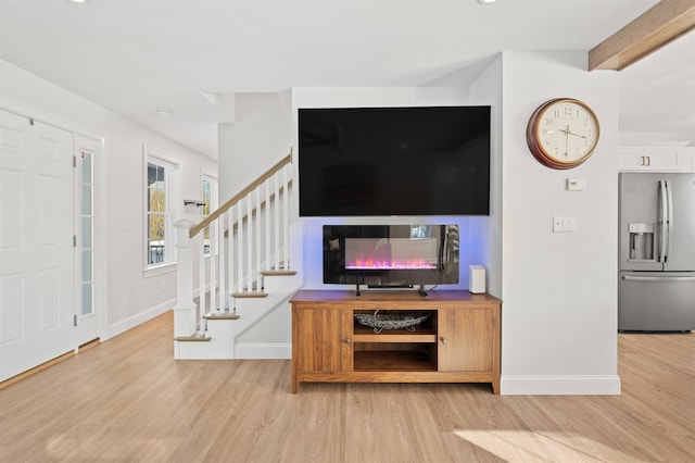 living area with stairs, baseboards, and wood finished floors