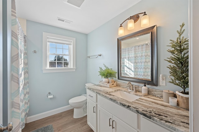 full bath featuring visible vents, toilet, wood finished floors, baseboards, and vanity